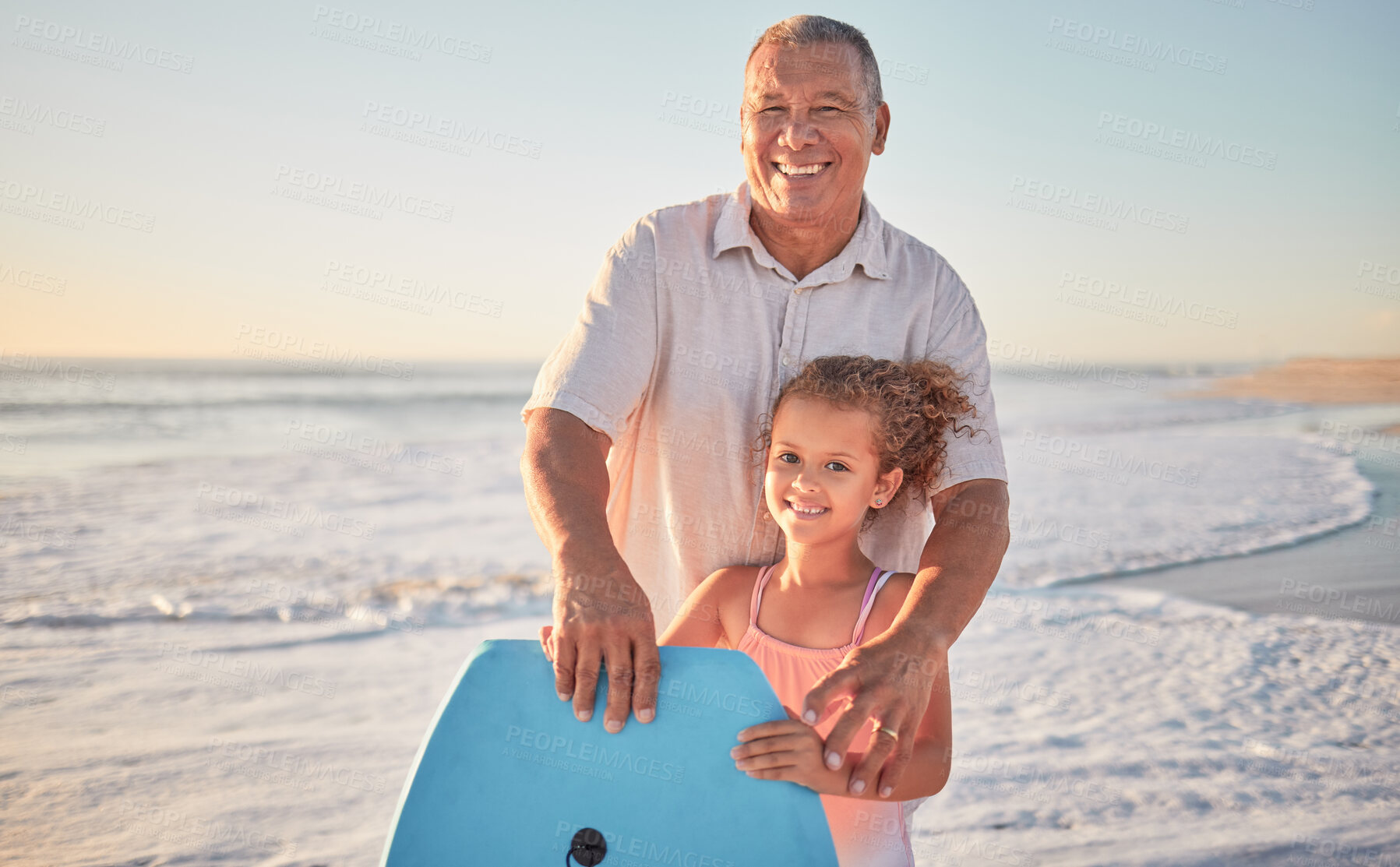 Buy stock photo Beach, grandfather and girl learning to surf from a happy senior man in her family on a summer holiday outdoors. Smile, sports and old man teaching or training a child surfing on a board in the ocean