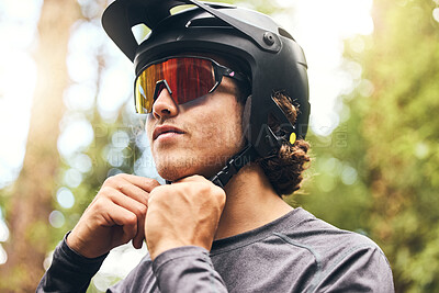 Buy stock photo Fitness, helmet and man cycling in nature on his bicycle outdoors for exercise, training and workout in spring. Sports person riding a bike and fixing headgear on an adventure in the forest or woods