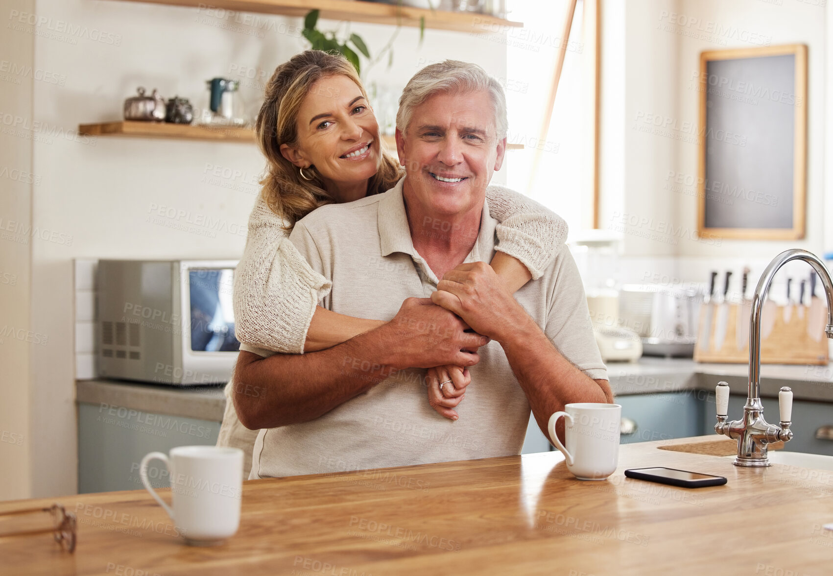 Buy stock photo Senior couple, smile and love while hugging in kitchen drinking coffee, relax and bonding feeling happy, support and trust. Portrait of old Australia man and woman in healthy relationship or marriage