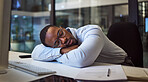 Black businessman, tired and sleeping on night office desk after programming computer code, database seo and cybersecurity ux. Burnout, exhausted and sleepy worker with documents deadline in Nigeria