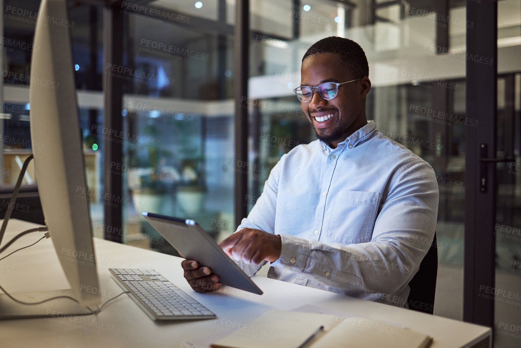 Buy stock photo Businessman working on digital tablet late in office at night, happy and inspired by career goal. Motivation, management and vision by black entrepreneur excited by innovation and new company