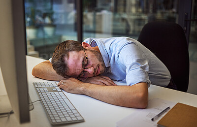 Buy stock photo Burnout, tired and sleep with a business man sleeping on his desk while working on a computer at a desk in his office. Mental health, problem and exhausted with a young male employee at work at night