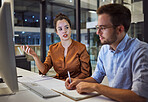 Business training, team planning and woman planning a corporate strategy on the internet with businessman in a dark office. Business people talking about idea for company partnership during overtime