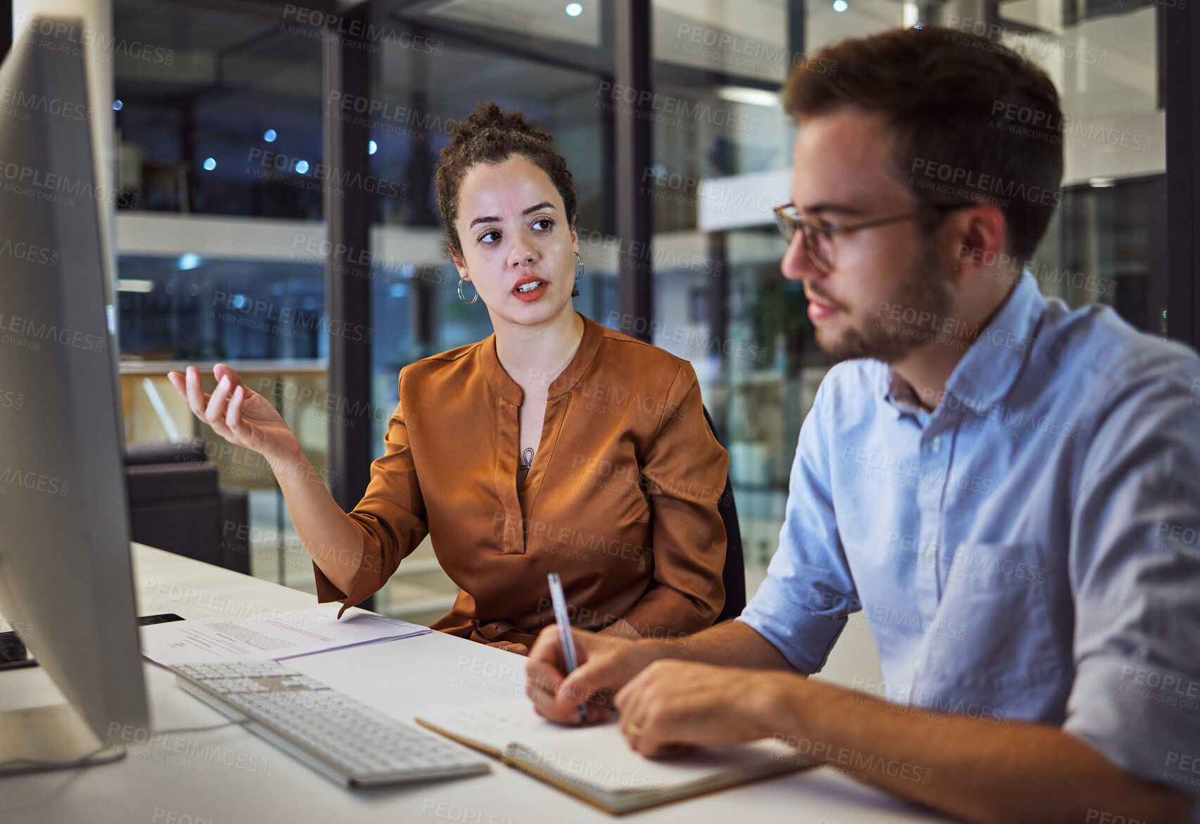 Buy stock photo Business training, team planning and woman planning a corporate strategy on the internet with businessman in a dark office. Business people talking about idea for company partnership during overtime