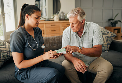 Buy stock photo Nurse, senior man and home care or consultation for healthcare and medicine prescription with a caregiver reading on medication box. Female medical worker talking to a old male sitting on a sofa