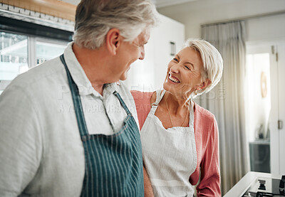 Buy stock photo Couple, cooking and love with a senior man and woman in the kitchen to prepare food or a meal at home. Retirement, happy and smile with an elderly male and female pensioner together in their house