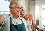 Elderly, couple and apron in home happy while cooking, baking or cleaning together in funny moment. Older man, woman and retirement laughing in kitchen, bonding and smile, to make food and joke