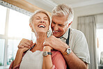 Love embrace, communication and senior couple holding hands and laughing at funny conversation in the living room of their house. Happy elderly man and woman with smile in retirement together