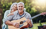 Couple, guitar and picnic with a senior man and woman in nature with a smile and music for fun and adventure. Happy, retirement and love with an elderly male and female pensioner in a park in summer