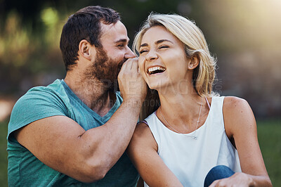 Buy stock photo Gossip, secret and funny story with couple on a romantic date in nature in Australia in summer. Man talking in a whisper into the ear of a young laughing woman while happy in a garden together