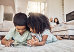 Children, brother and sister on tablet watching, learning or streaming educational videos, games or cartoon on lounge carpet at home. Kids playing on internet for fun and entertainment in brazil