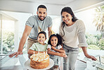 Happy, smile and portrait of a family at birthday celebration with cake, candles and fun hats at home. Happiness, excited and children celebrating with their parents at a party in their modern house.