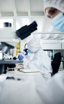 Buy stock photo Science, laboratory and scientist doing covid research on dna, rna and medical development with a microscope. Scientists in hazmat suits, face mask and safety gloves busy working experiment testing 