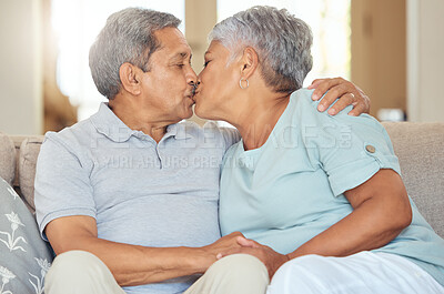Buy stock photo Senior couple, kiss and love at home while sitting on sofa in lounge to bond, relax and enjoy free time during retirement. Old man and woman sharing romantic and sweet moment in their Mexico house