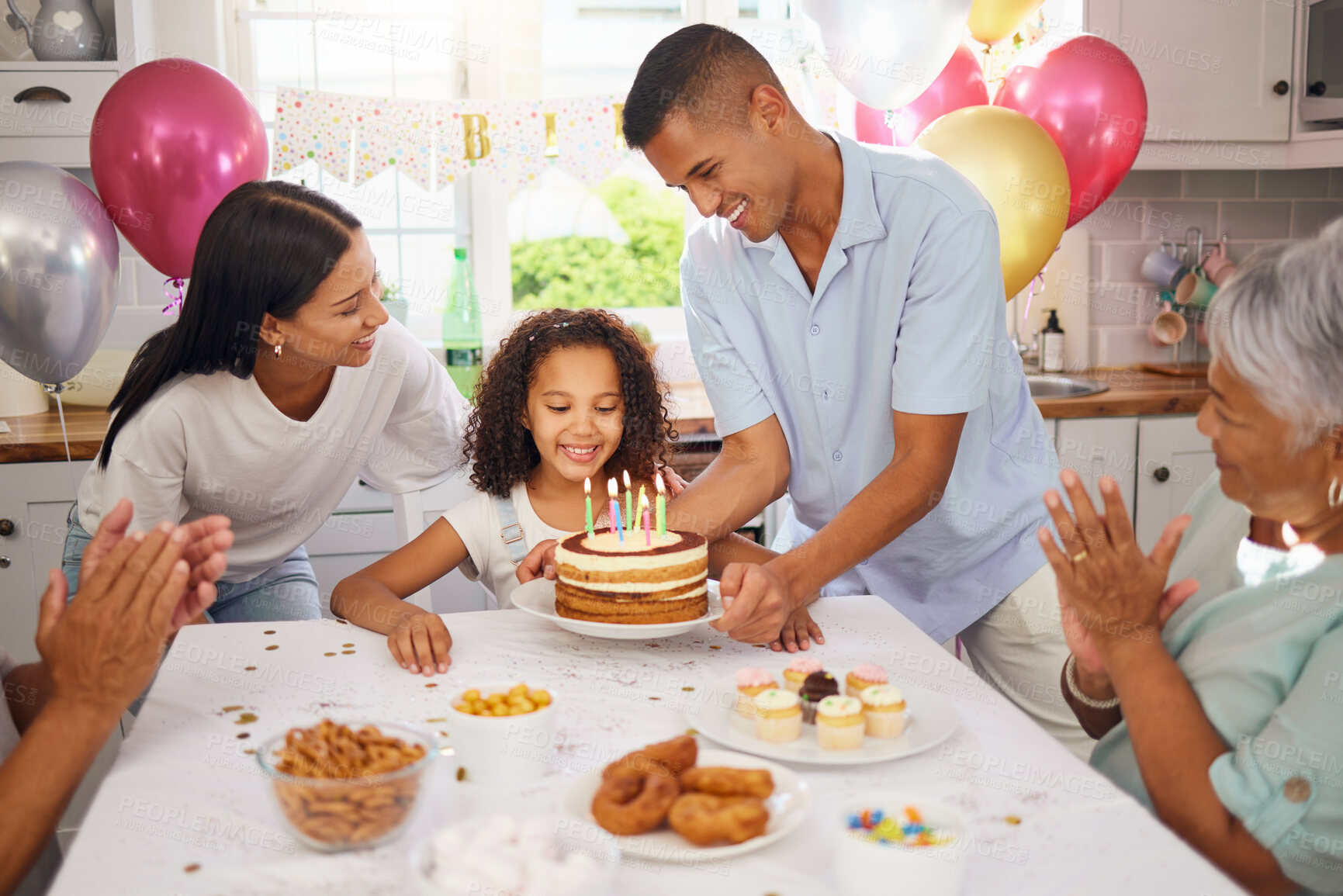 Buy stock photo Child, birthday cake and celebration party with family and parents of a happy and excited girl ready to blow her candles at home. Cute kid at a table in her Puerto Rico house with balloons and snacks 
