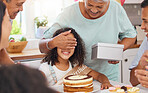 Child, birthday present and celebration party with grandma covering eyes for gift box surprise from family at home. Cute kid at a table in her Puerto Rico house with cake and sweet snacks on a table

