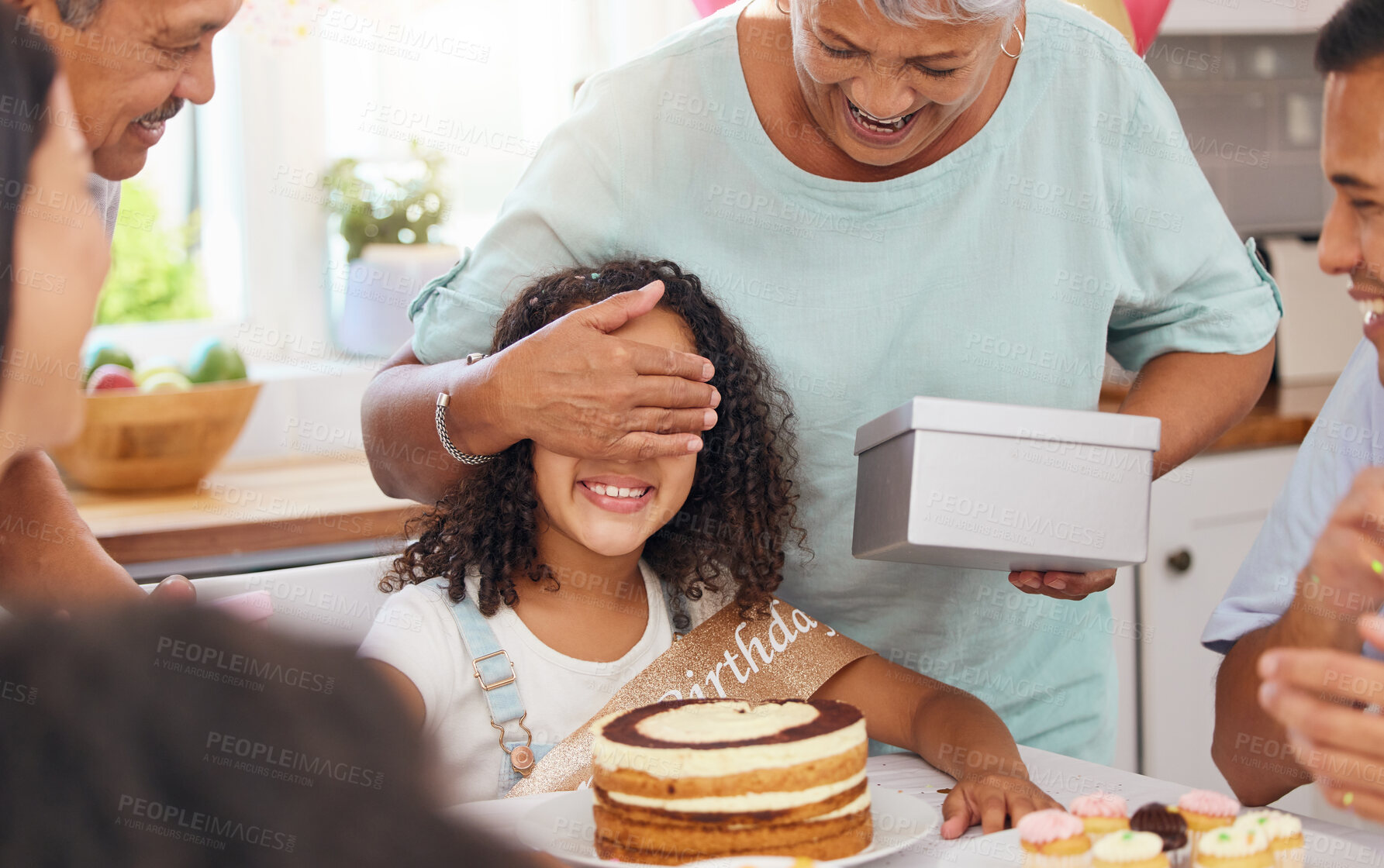 Buy stock photo Child, birthday present and celebration party with grandma covering eyes for gift box surprise from family at home. Cute kid at a table in Puerto Rico house celebrating with cake and snacks on table
