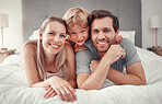Mother, father or boy bonding in bedroom at home, house or hotel in trust, security or safety. Family portrait, smile or happy man or woman with child, kid or son in relax support in Canada apartment