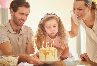 Buy stock photo Birthday, candles and family celebration with cake, parents and girl for a happy family event. Happiness, love and smile of a mother, father and young daughter together blowing a candle in a home