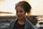 Portrait beautiful mixed race woman smiling confidently on seaside beach at sunset