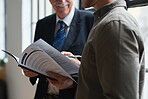 Senior businessman talking to colleague boss mentoring sharing business experience holding documents in office