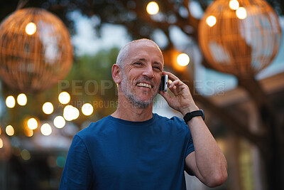 Mature man using smartphone having phone call talking on mobile phone city evening
