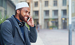 Muslim businessman using smartphone talking on mobile phone in city smiling happy