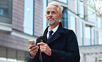 Senior businessman using smartphone in city texting on mobile phone