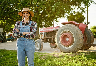 Buy stock photo Farm, agriculture and tractor with a young woman farmer standing outside in the farming industry. Sustainability, organic and eco friendly agricultural harvest during summer or spring harvest season