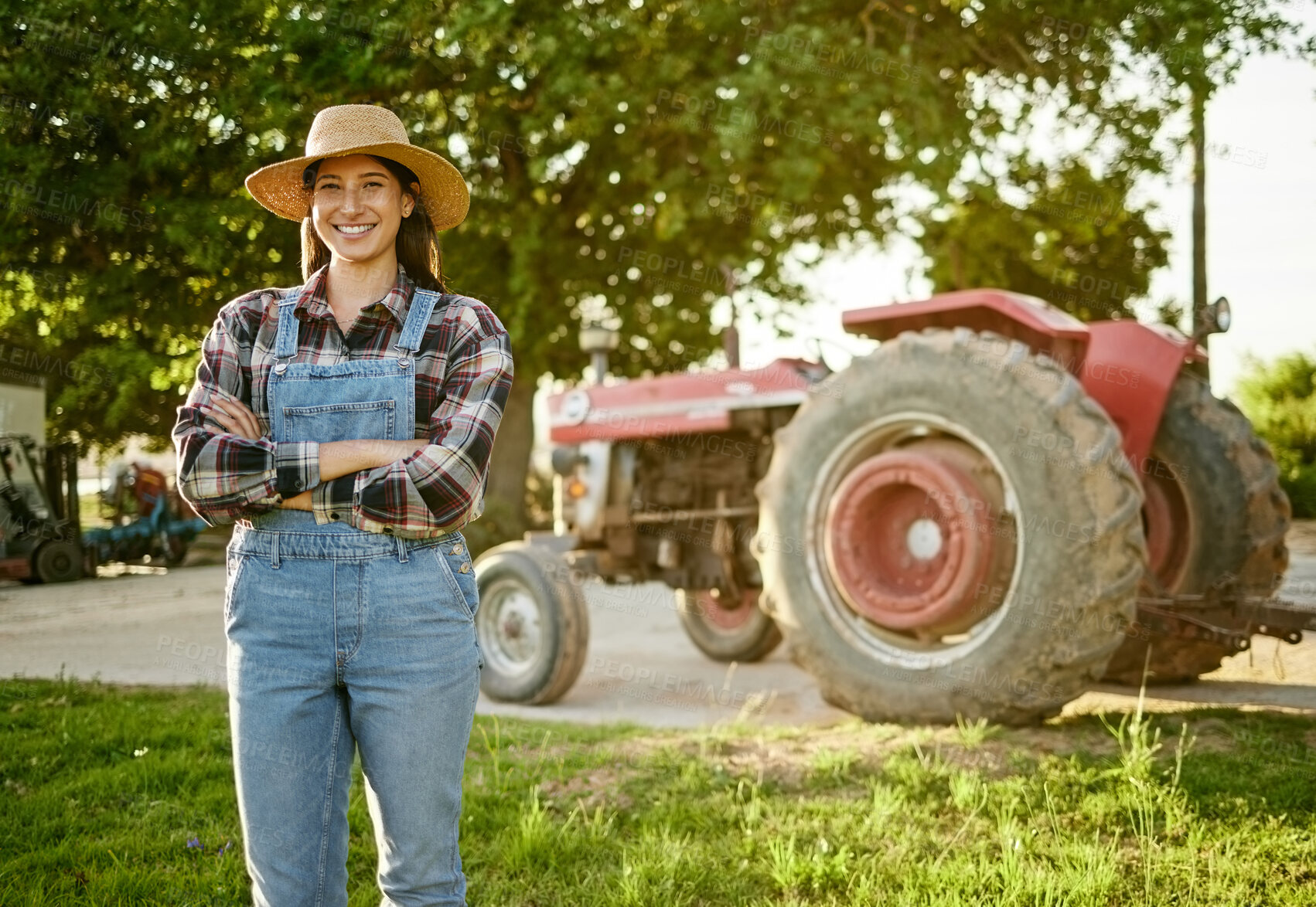 Buy stock photo Farm, agriculture and tractor with a young woman farmer standing outside in the farming industry. Sustainability, organic and eco friendly agricultural harvest during summer or spring harvest season