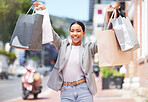 Shopping, retail and celebration with a young woman and consumer in the city after spending money in a store, shop or mall. Happy and excited customer with a smile and bags on an urban background