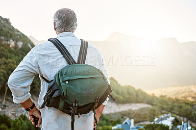 Buy stock photo Rear view of exploring, active and adventure senior man standing with a backpack after a hike, enjoying the landscape and forest nature. Male hiker looking at nature environment sunrise view