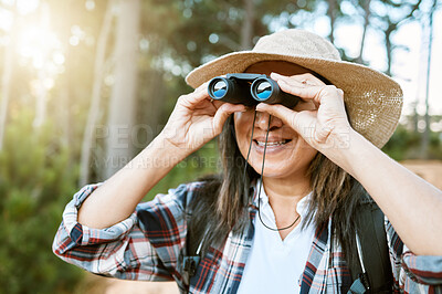 Buy stock photo Female tourist hiking, looking through binoculars at wild birds in the trees. Happy, carefree and mature woman on nature walk, enjoying the view. Outdoor holiday time to promote health and wellness.
