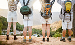 Fitness group celebrating on hike in nature, enjoying hiking view on a mountain on a wellness getaway vacation together. Back of friends walking on weekend and relaxing on summer holiday