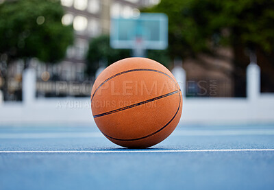 Basketball on the floor of a sports court during training for a game in summer outdoors. Closeup of orange ball for athlete team to practice their strategy for fitness and exercise in outside stadium