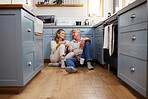 Coffee, morning communication and senior couple talking on the kitchen floor together in their house. Happy, calm and peace for elderly man and woman with tea drink and conversation during retirement