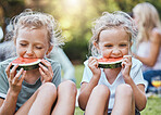 Happy, picnic and watermelon with children in park with family for summer, wellness and relax. Health, nature and spring with kids eating fruit in countryside field for peace, friends and food