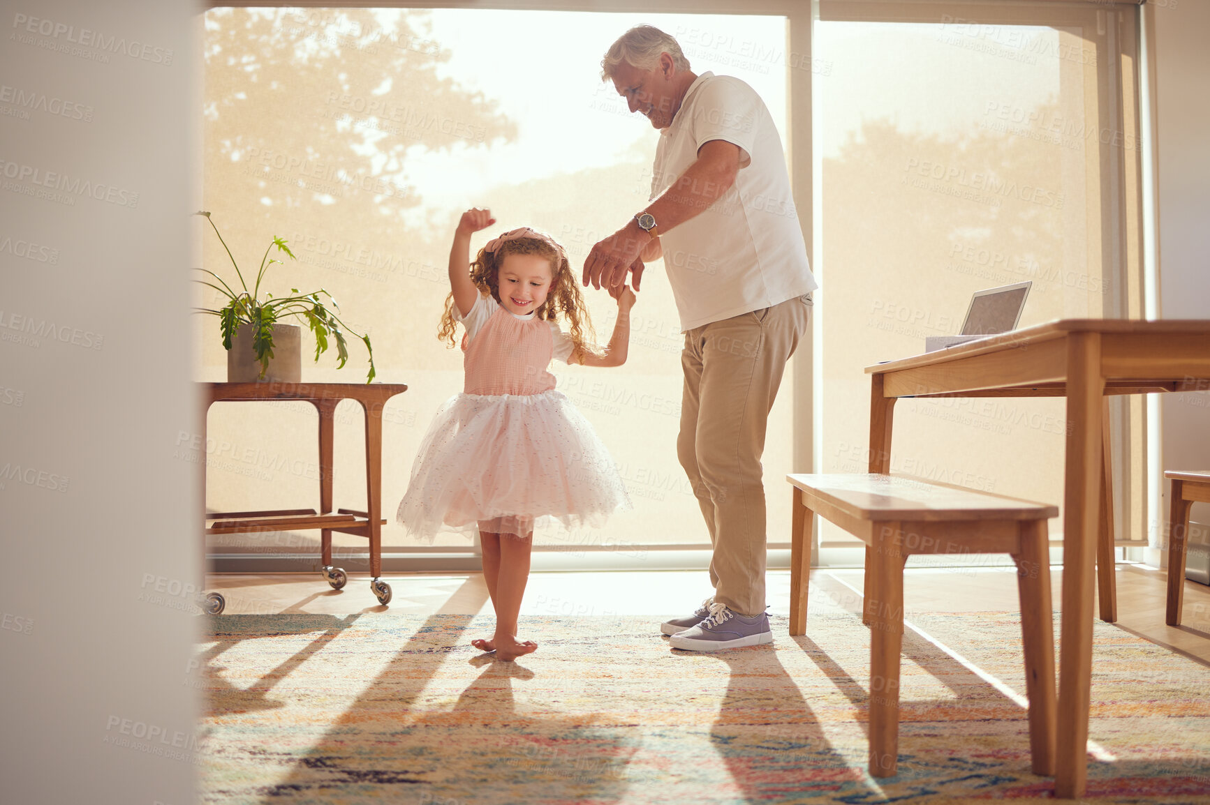 Buy stock photo Family, young girl and grandfather dancing in living room together. Grandparent and grandchild in family home doing dance and having fun in the morning. Old man enjoying retirement with child at home