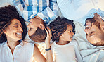 Love, relax and happy family in bed, laughing, bonding and resting in their bedroom together from above. Black, cheerful and young parents enjoying time with their kids, conversation and sweet moment