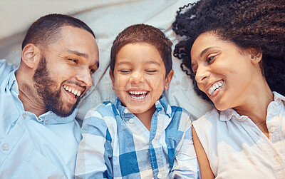 Buy stock photo Parents, child and smile in bed for happy closeup together to relax together at family home. Mother, dad and kid laughing after comic, funny or silly joke show happiness on blanket at their house