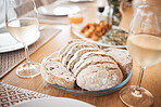 Sourdough bread, food and lunch meal for fine dining, eating and dinner table in house, restaurant and cafe. Closeup slice of wheat grain baguette, nutrition and artisan rye on plate enjoy with wine
