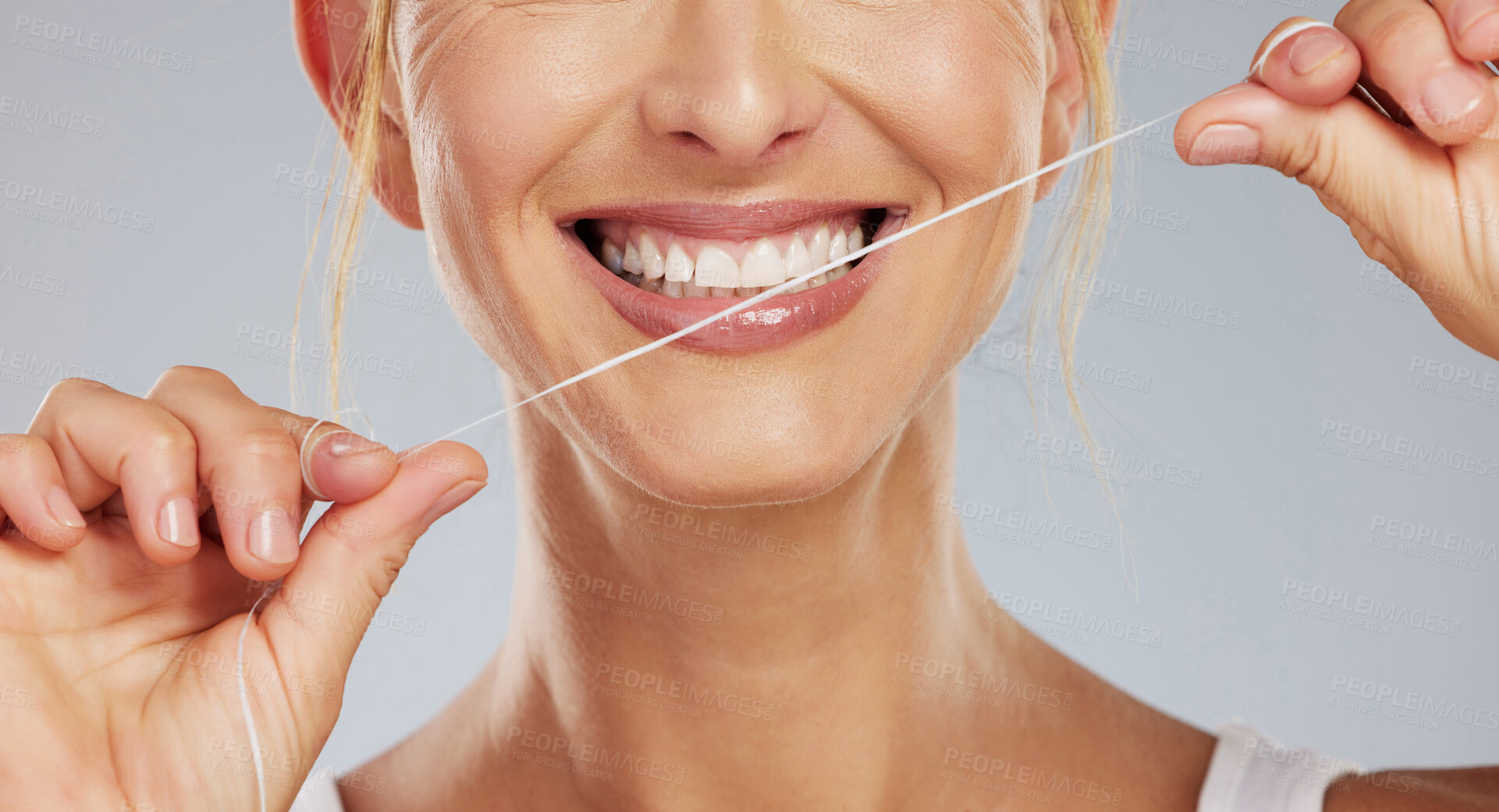 Buy stock photo Teeth flossing, dental wellness and woman with smile while cleaning mouth against grey mockup studio background. Hands of model with string to care for tooth health and oral healthcare with smile