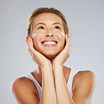Face, beauty and skincare with a beautiful woman in studio on a gray background for antiaging or healthcare. Health, body and care with a mature female applying lotion or cream to her skin