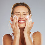 Face, cleaning and hygiene with a mature woman washing her skin in studio on a gray background. Skincare, healthcare and beauty with a female keeping her head clean, fresh and hygienic with a routine