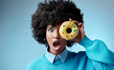 Buy stock photo Wow, surprise and donut on eye of black woman feeling shocked with sugar, dessert or sweets against a blue background studio. Candy, food and cake with girl and omg emotion for deal, sale or alert