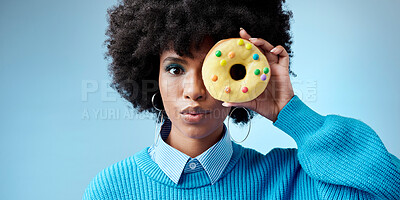 Buy stock photo Beauty, black woman and donut portrait over face, celebration of Africa and sweet style on eye with blue background. Fashion, African model and cake with feminism, empowerment and excited happiness.