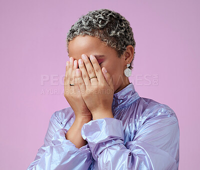 Buy stock photo Hands, shy and hiding black woman in studio, embarrassed by trendy fashion and edgy makeup. Beauty, hand and face covering by cute lady hide after glamour and makeover against pink background mockup