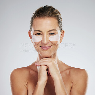 Buy stock photo Mature woman, beauty and eye patches on a gray studio background. Skincare, health and female model with face and facial makeup cosmetics or collagen pads for skin wellness, hydration or anti aging.