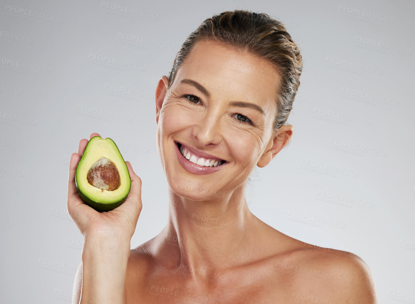 Buy stock photo Natural skincare, senior woman with avocado and happy studio portrait. Facial treatment, nutrition in green fruit and healthy lifestyle. Organic food with smile, wellness beauty and gray background