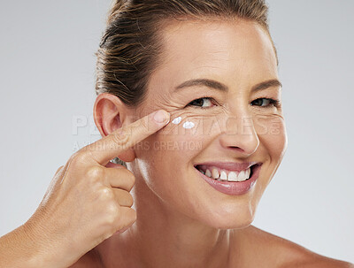 Buy stock photo Mature model, skincare and cream on face for beauty, health and happiness with studio background. Woman, skin and happy for anti aging product for facial, cosmetic and wellness in portrait with smile